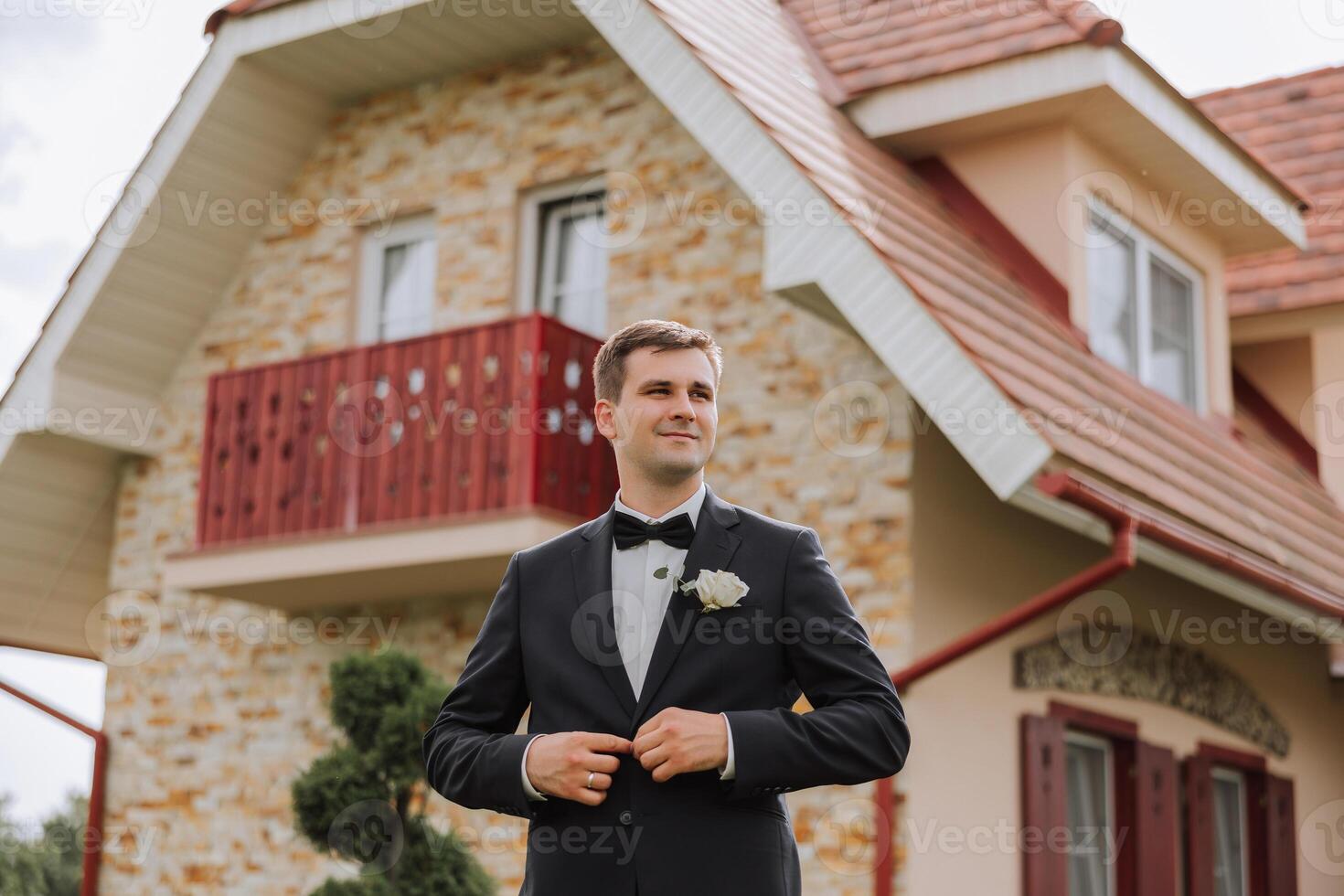 Portrait of the groom in nature in the summer. Stylish tall groom in an elegant black business suit. Businessman in nature. Portrait of a successful man. Wedding portrait of the groom. photo
