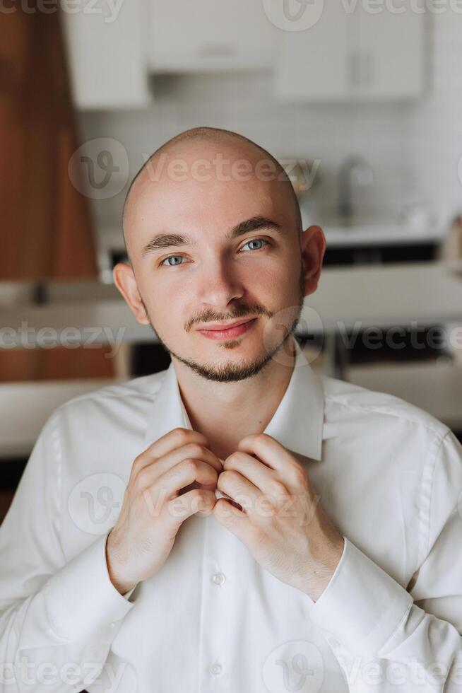 negocio camisa. un hombre en un blanco camisa sujeta el botones. joven político, masculino estilo, empresario abotonarse camisa, masculino manos de cerca, americano, europeo empresario foto