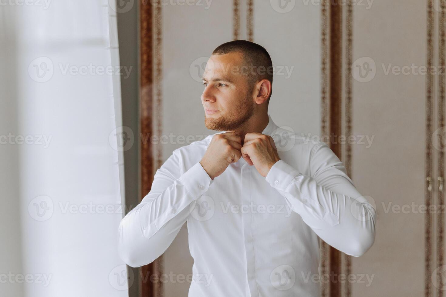 negocio camisa. un hombre en un blanco camisa sujeta el botones. joven político, masculino estilo, empresario abotonarse camisa, masculino manos de cerca, americano, europeo empresario foto