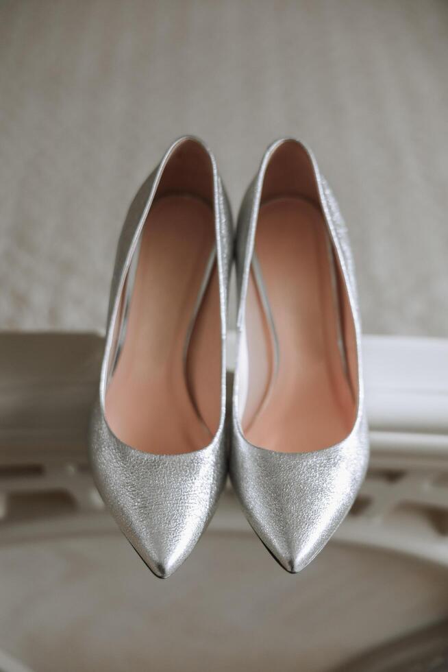 Bride's shoes. The girl wears stilettos. Elegant women's shoes. Beautiful details. The bride puts on her shoes and prepares for the wedding ceremony photo