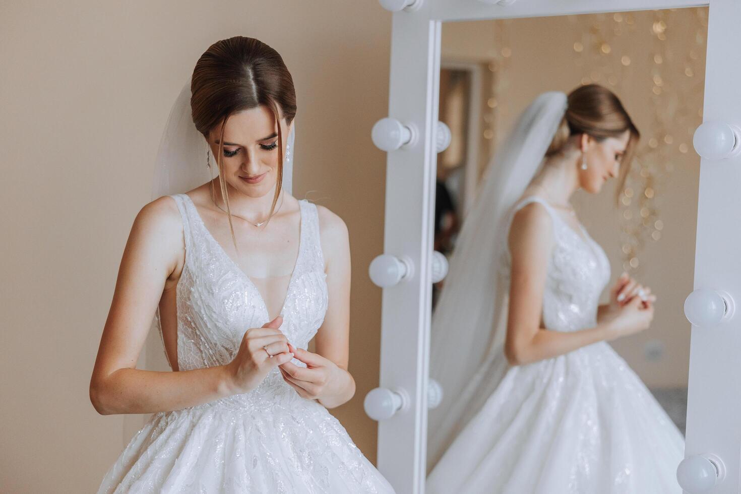 Portrait of the bride in the hotel room. A beautiful young girl is dressed in a white wedding dress. Modern wedding hairstyle. Natural makeup. photo