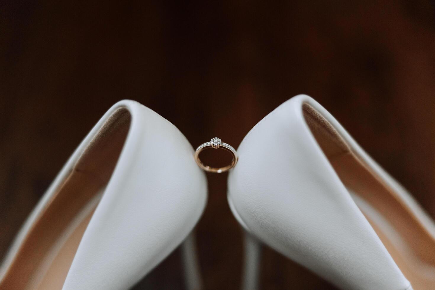 Bride's shoes. The girl wears stilettos. Elegant women's shoes. Beautiful details. The bride puts on her shoes and prepares for the wedding ceremony photo