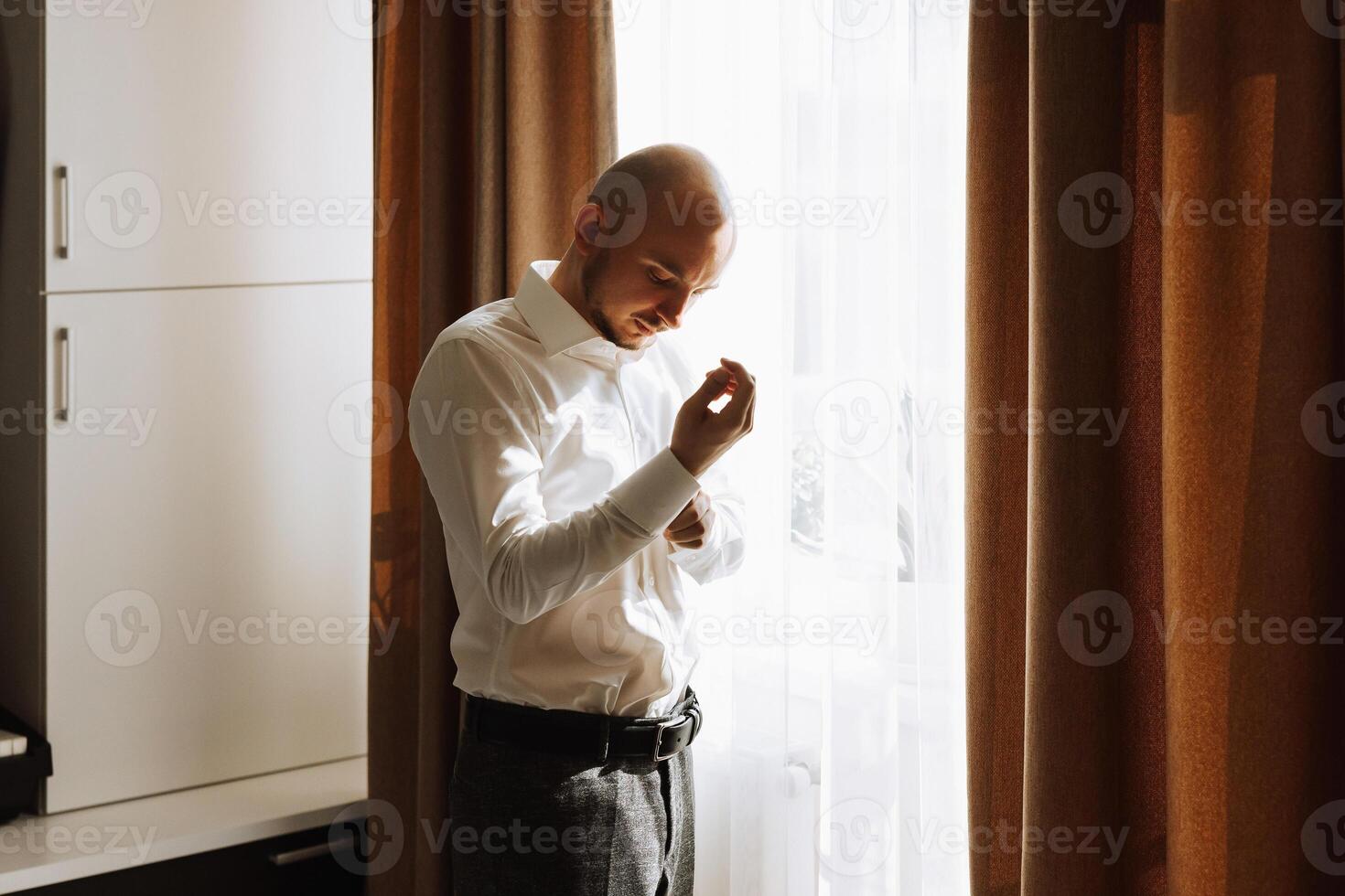 Business shirt. A man in a white shirt fastens the buttons. Young politician, male style, businessman buttoning shirt, male hands close-up, american, european businessman photo