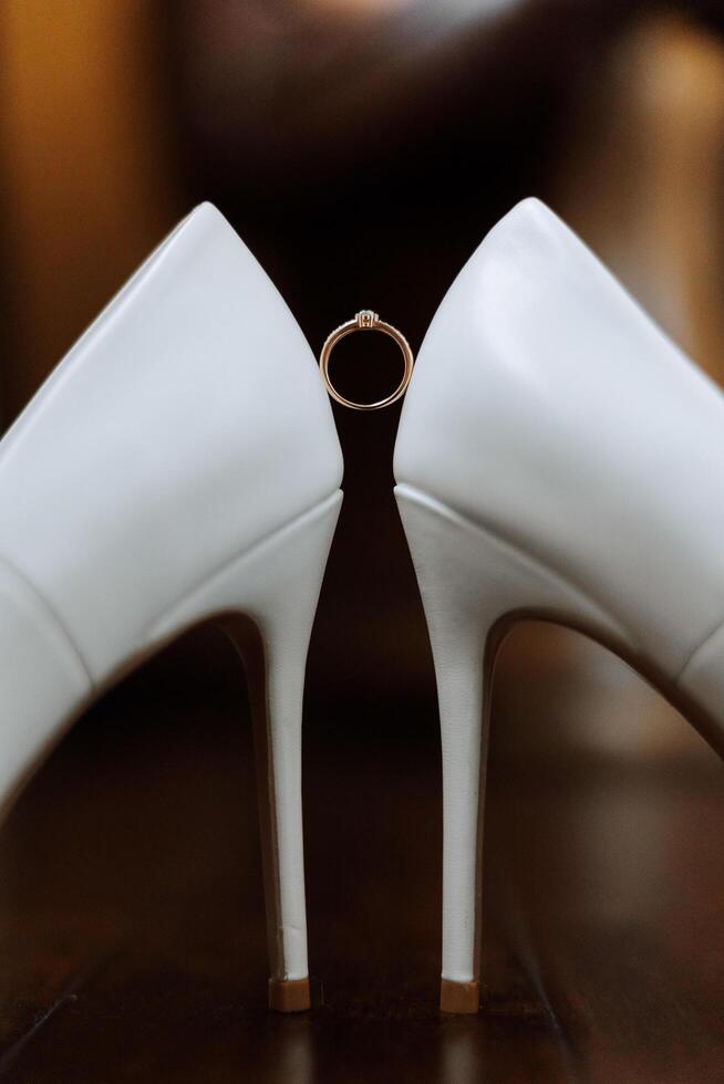 Bride's shoes. The girl wears stilettos. Elegant women's shoes. Beautiful details. The bride puts on her shoes and prepares for the wedding ceremony photo