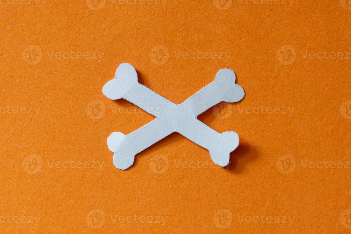 white cross bone in orange background photo