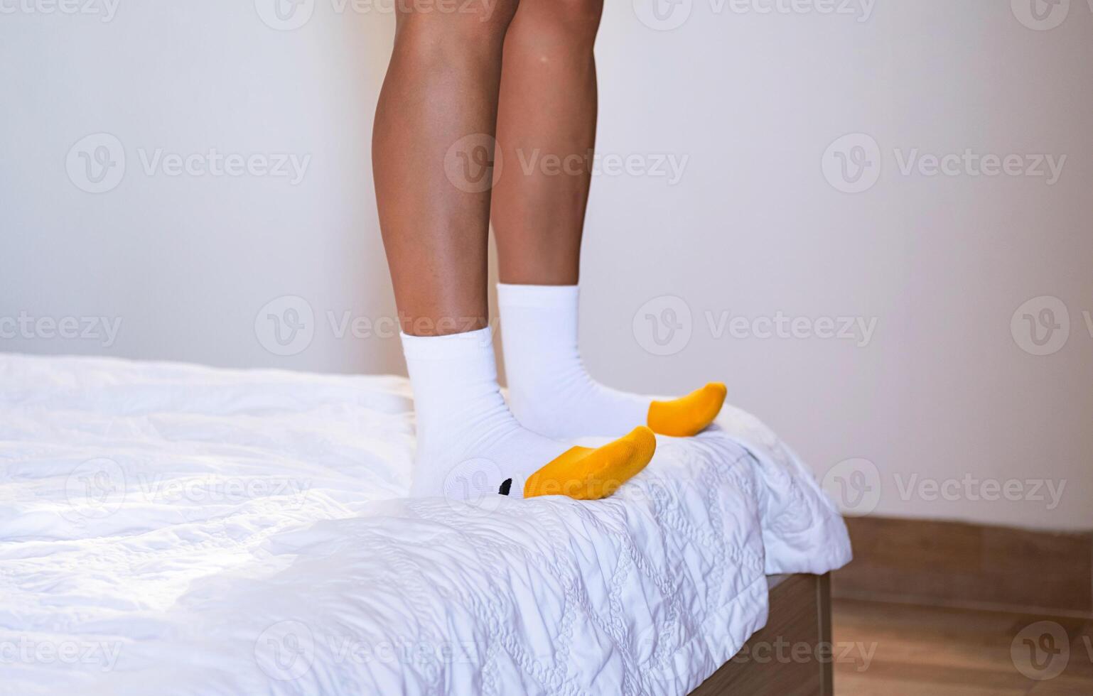 Woman's feet in funny socks on the bed at home. photo