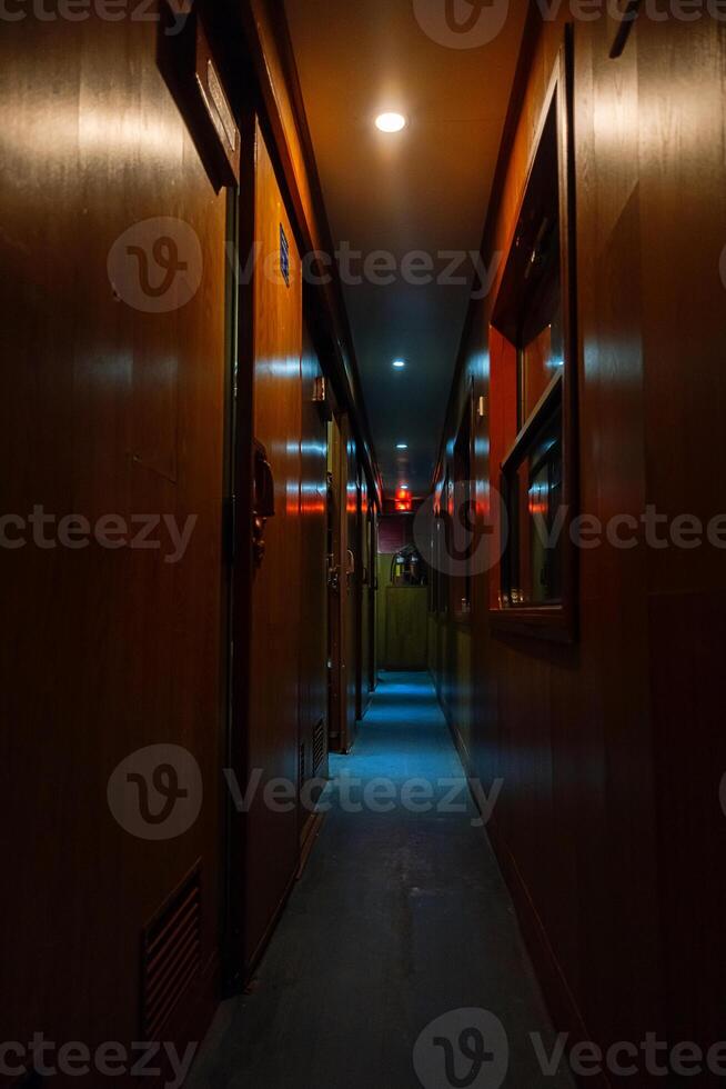 Empty vintage corridor of railway sleeping car at dusk. photo