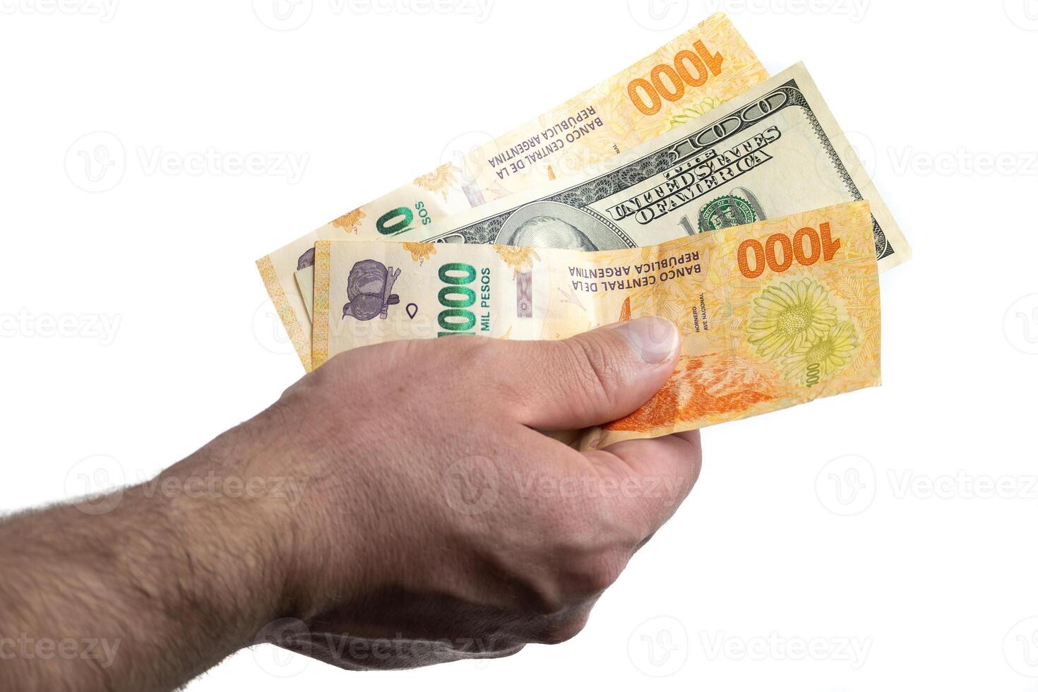 Hand with Argentine and dollar bills. photo