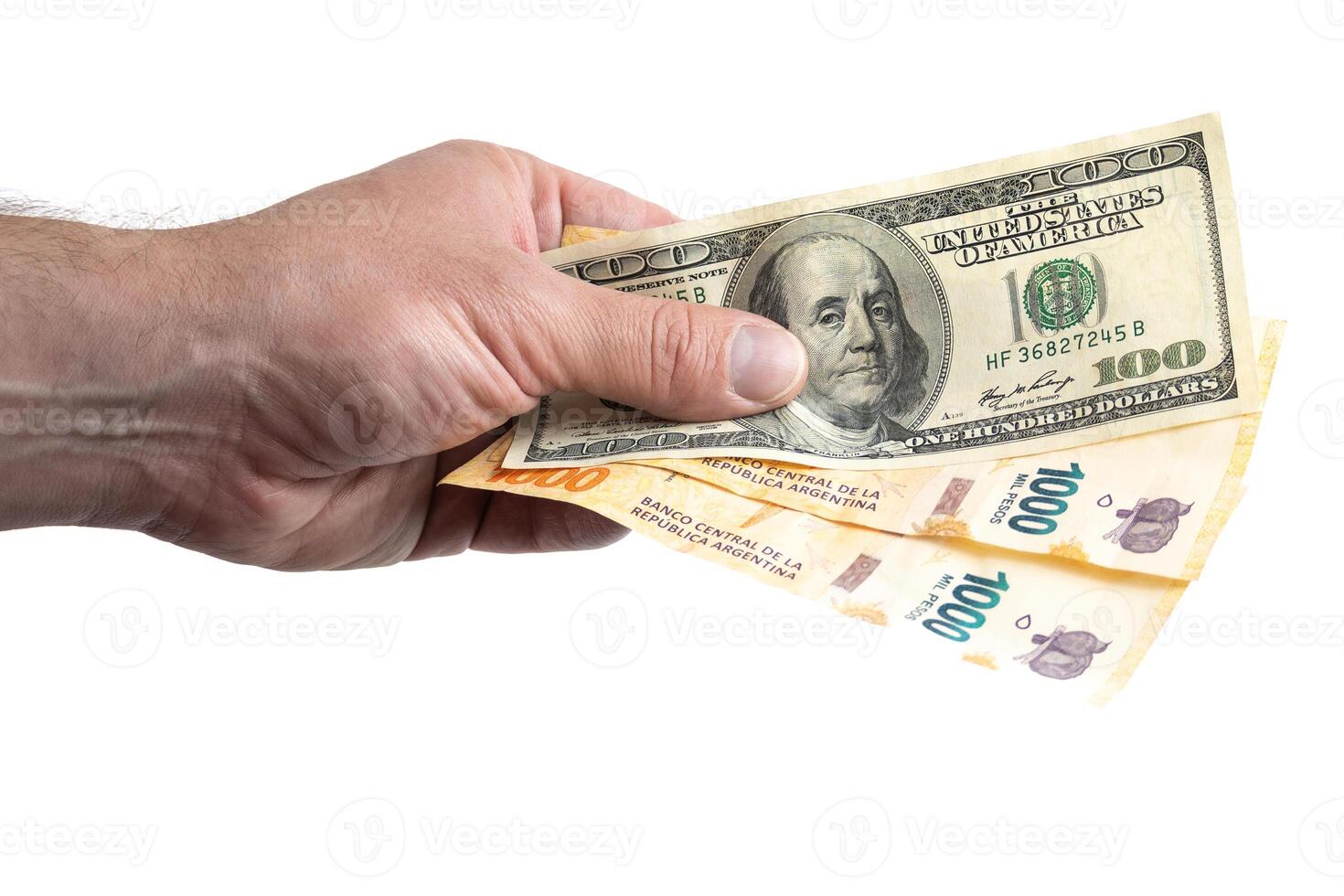 Hand with Argentine and dollar bills. photo