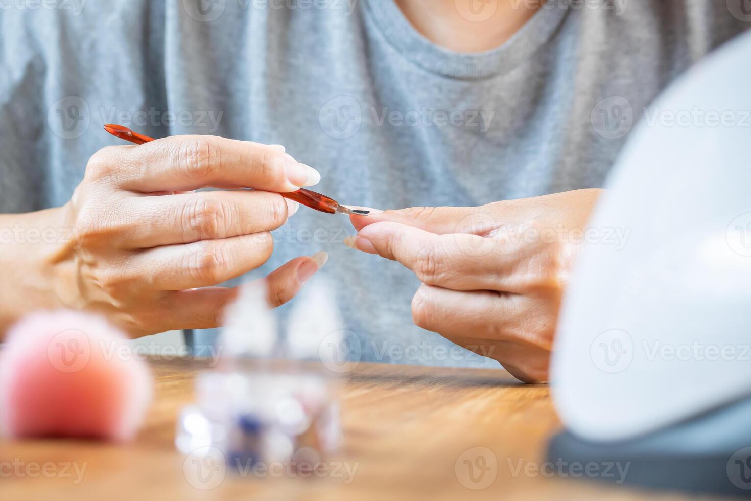 Woman using a cuticle remover, preparation before applying paint on nails. photo