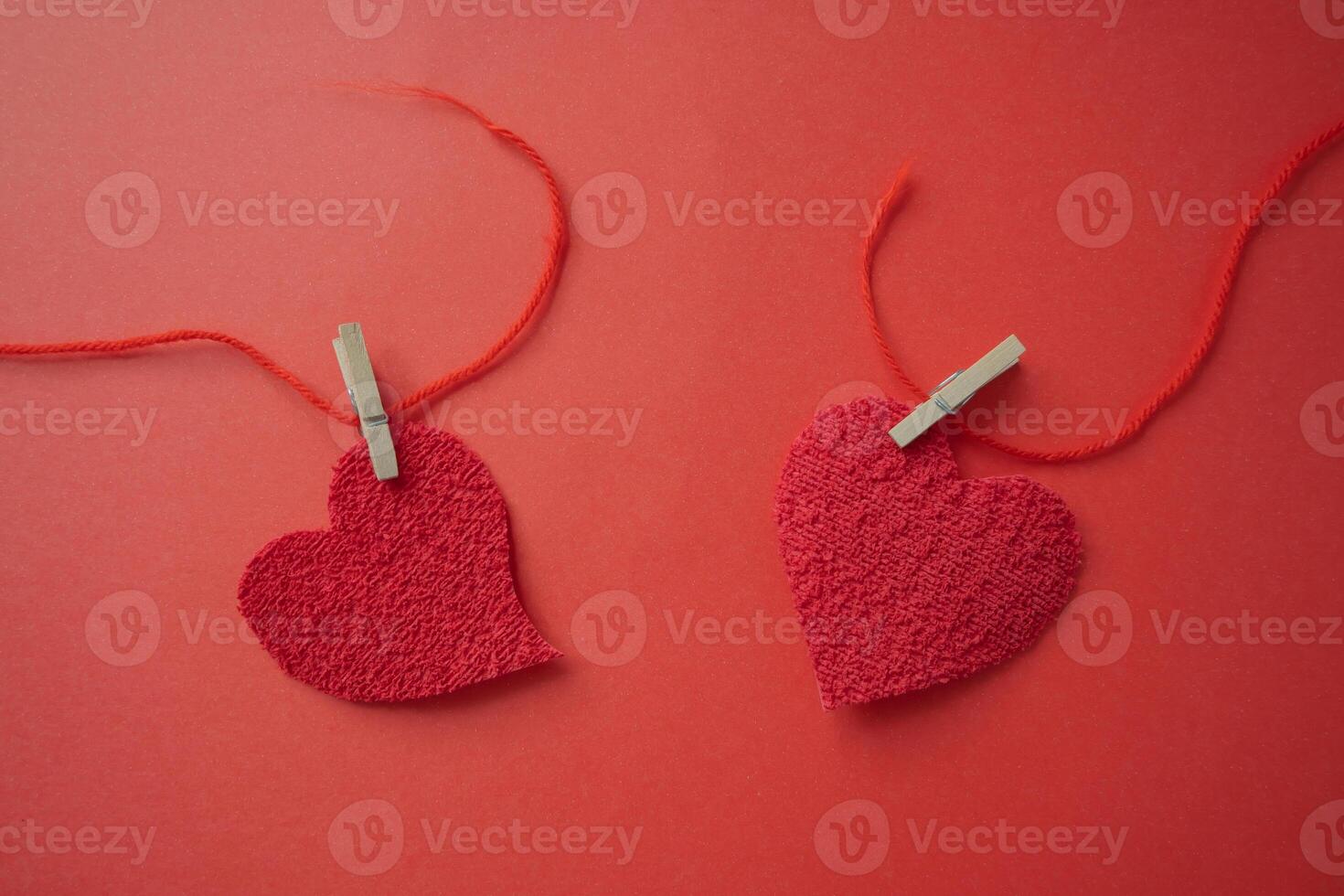 Two hearts that were joined with a red thread that breaks. photo