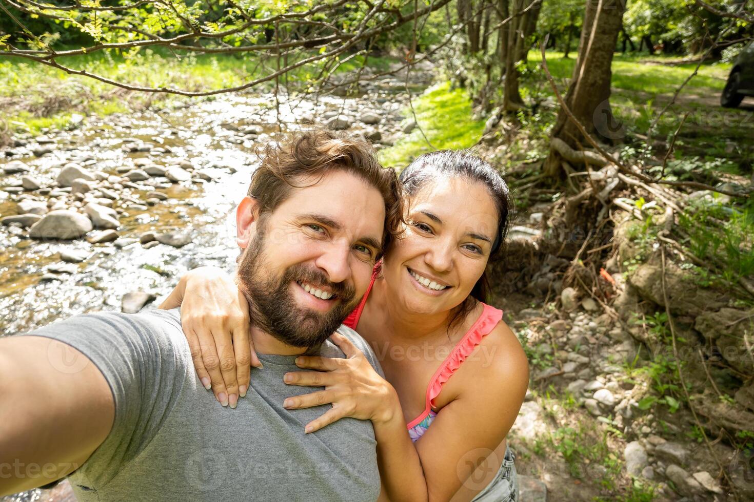 They are happy, smiling and in love. They are a happy couple taking a selfie. photo