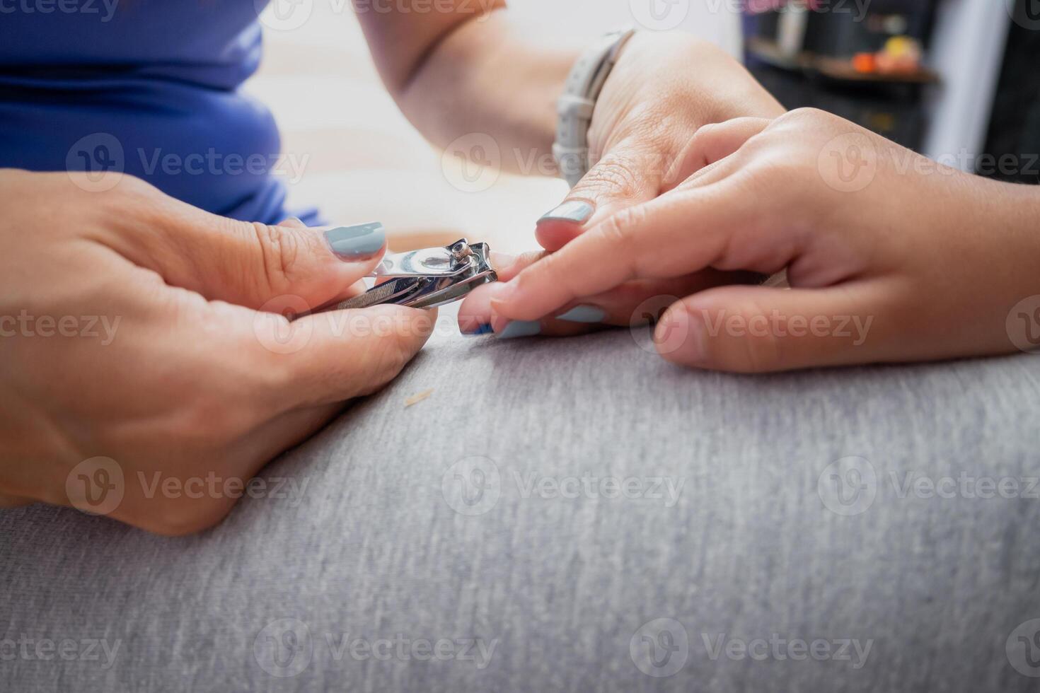 Mother cutting her daughter's nails photo