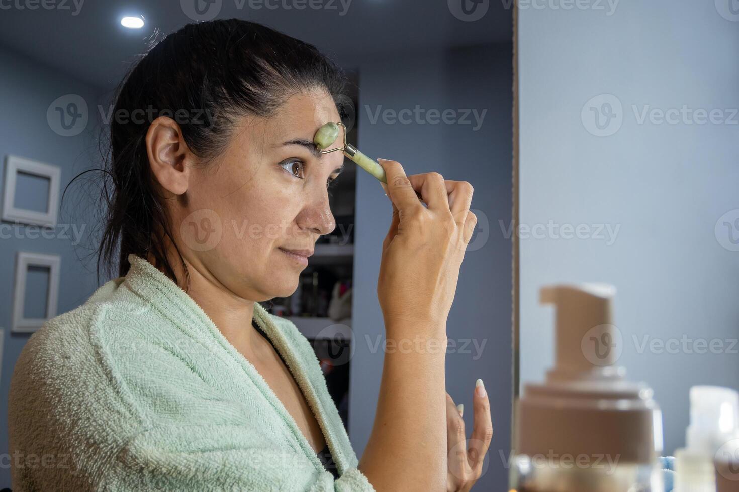 Girl doing her evening facial massage routine. photo
