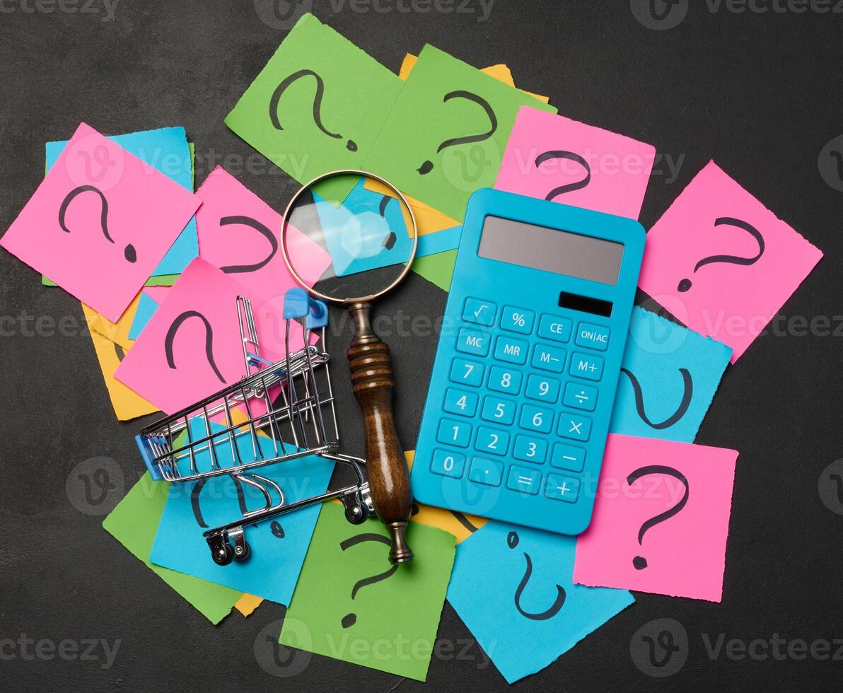 Drawn question marks on stickers and a magnifying glass, yellow background. photo