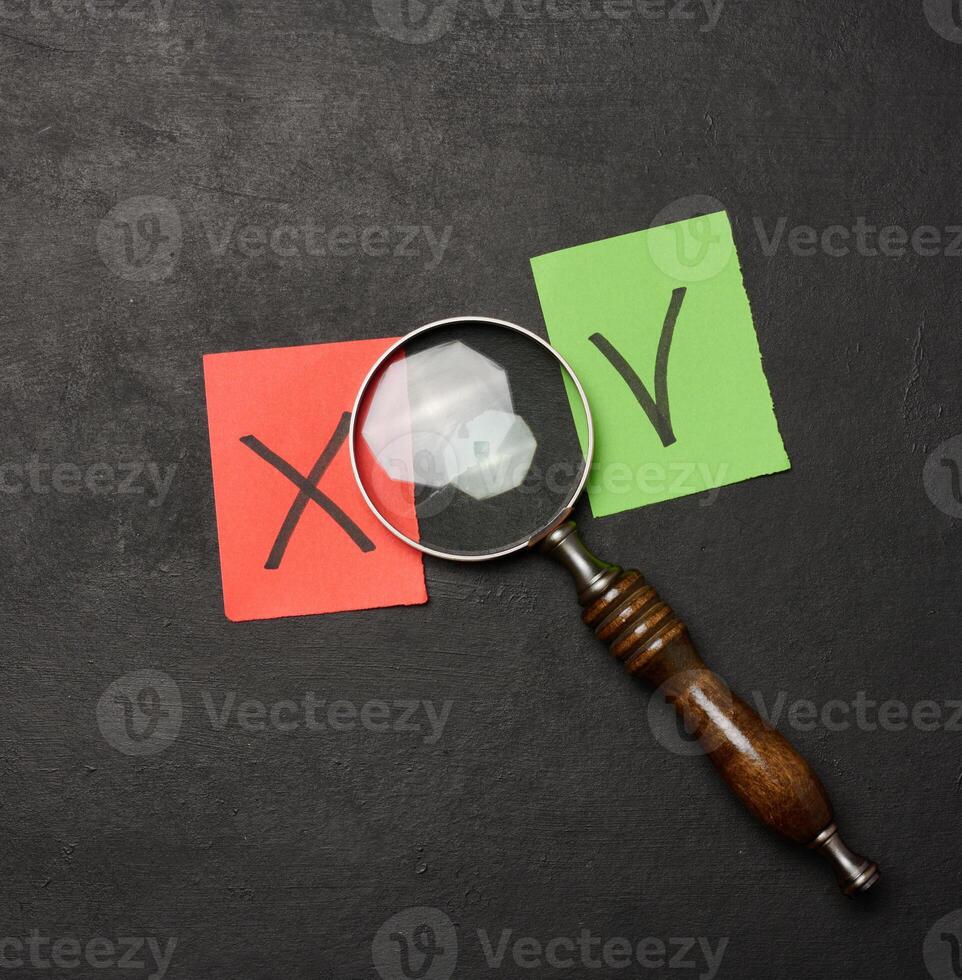 Two paper sheets with drawn check mark and cross symbols, representing the concept of error and correction photo