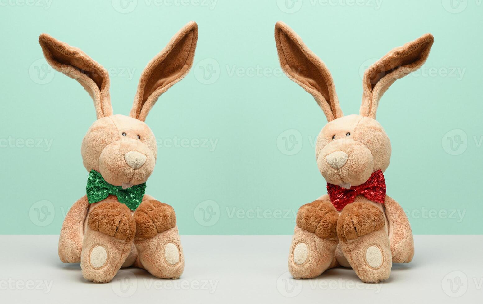 Two plush hares with a bow tie around their neck photo