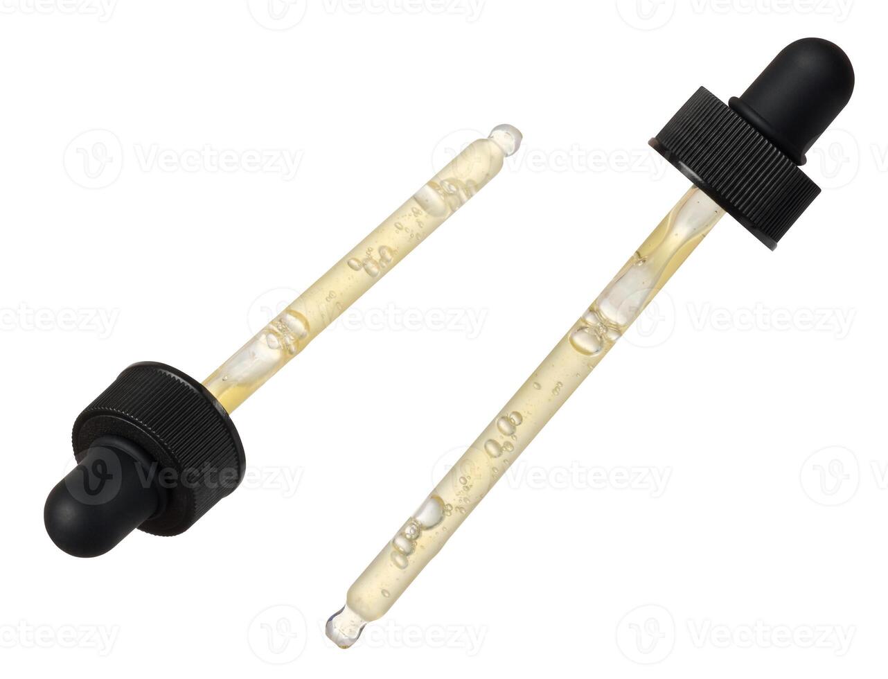 Transparent glass pipette with yellow liquid on isolated background photo