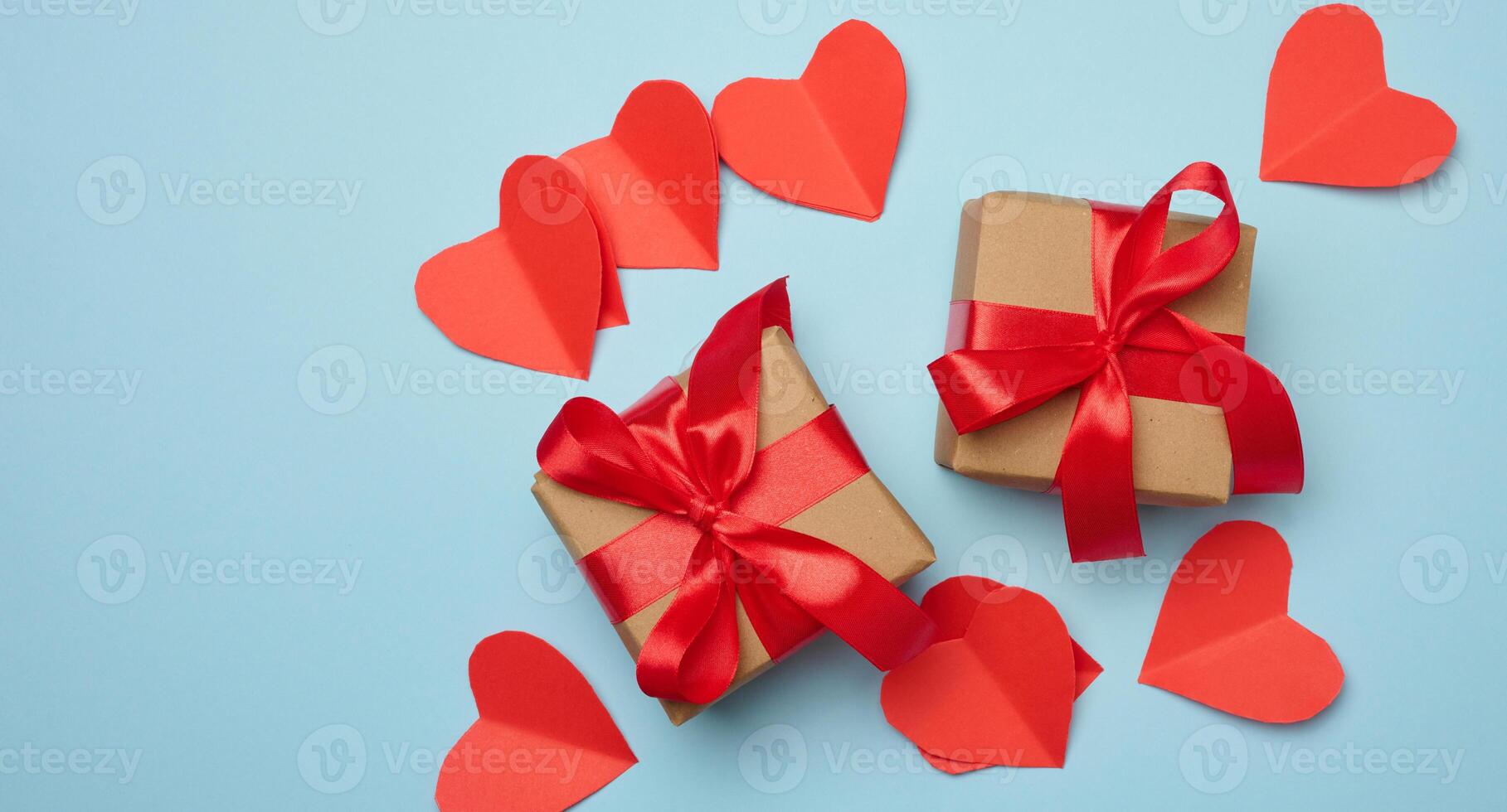 Gift box with red satin ribbon and bow on a blue background.Holiday background with Birthday or Christmas present, flat lay photo