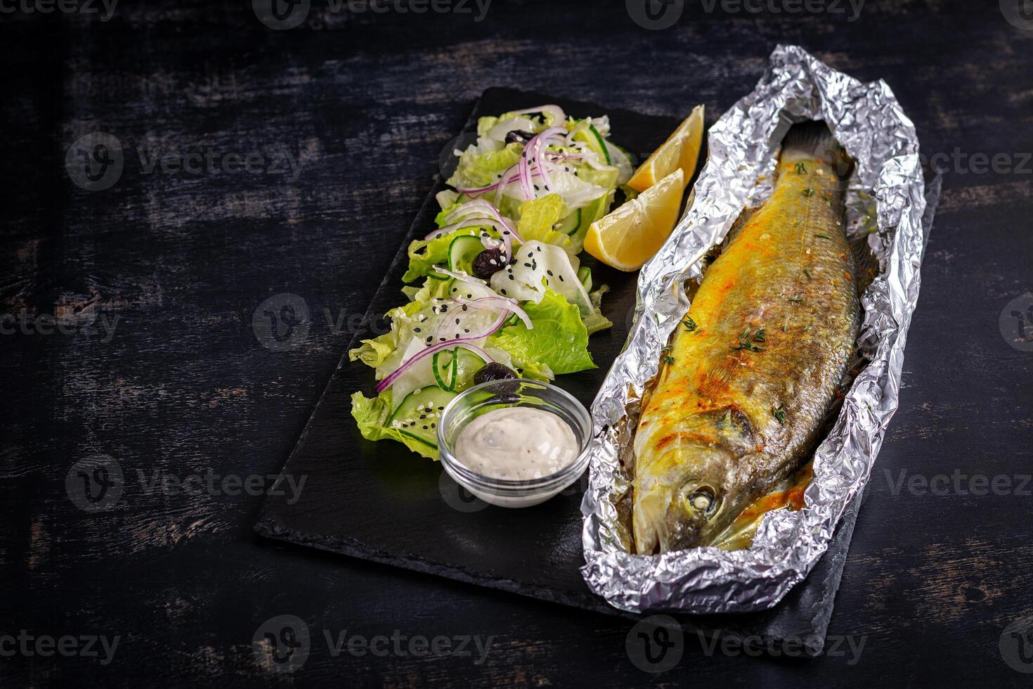 Baked sea bass and green salad. Healthy eating. Keto, ketogenic diet. Top view photo