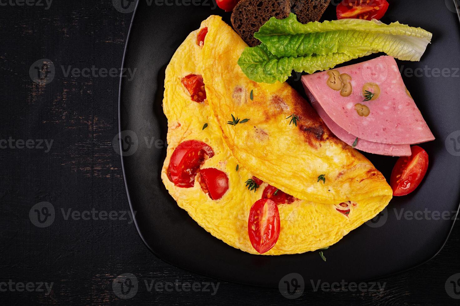 Omelette with tomatoes and cheese with bread and mortadella sausage. Top view photo