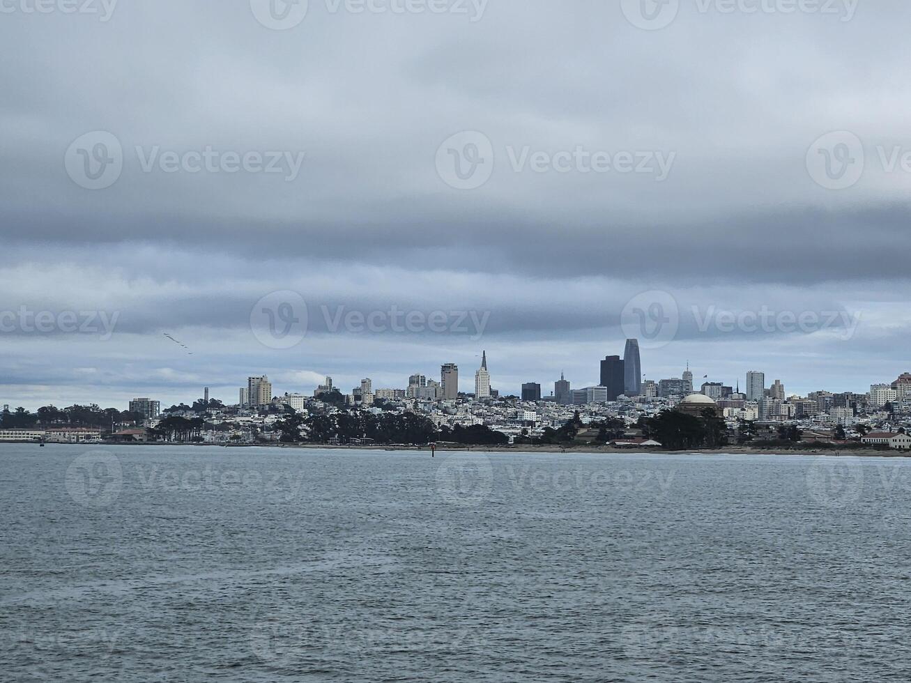 San Francisco skyline from golden gate bridge beach with a view of Alcatraz island in a cloudy day photo