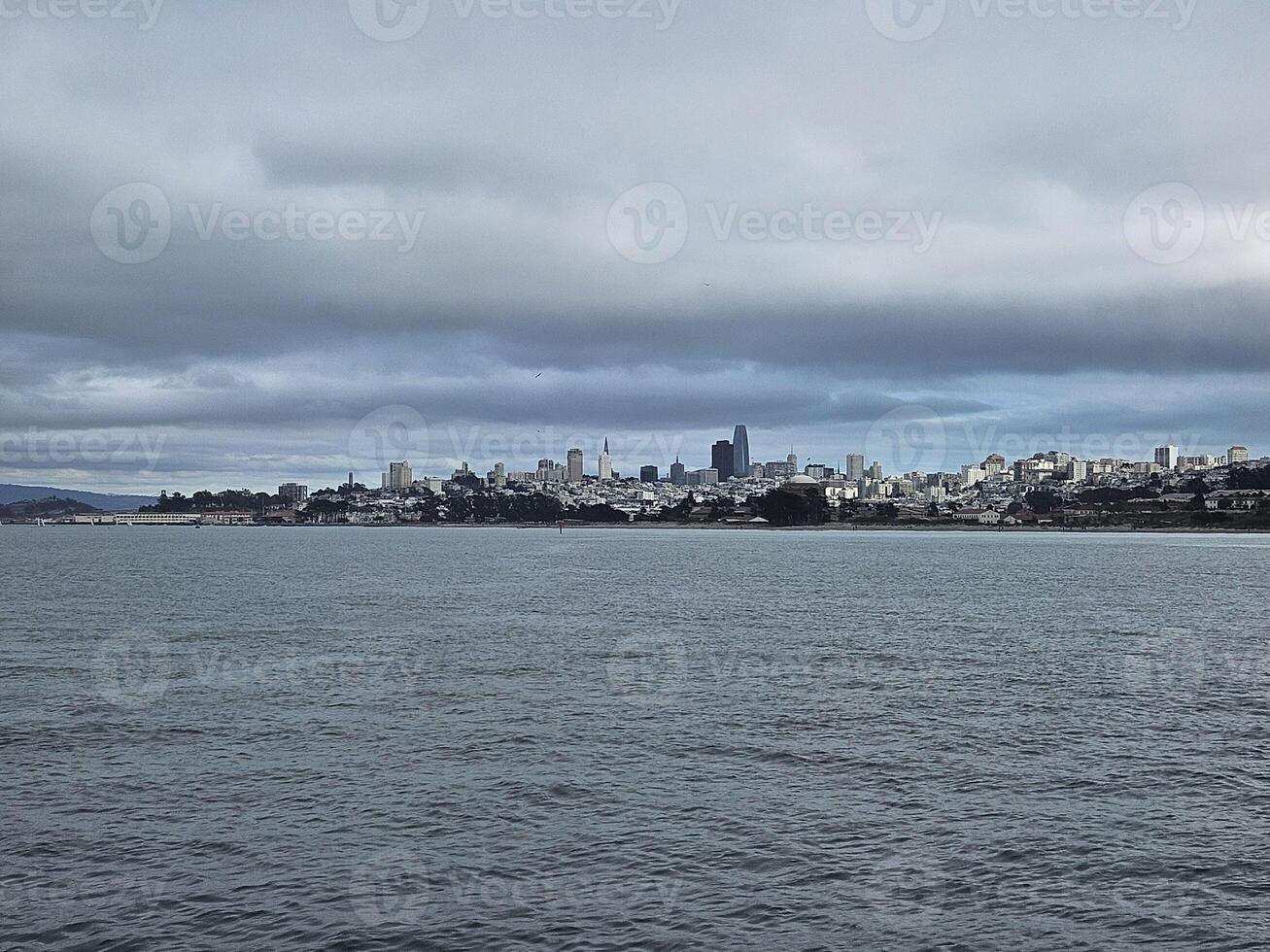 San Francisco skyline from golden gate bridge beach with a view of Alcatraz island in a cloudy day photo