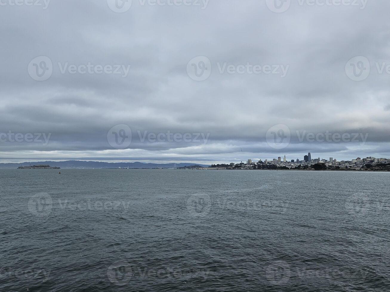 San Francisco skyline from golden gate bridge beach with a view of Alcatraz island in a cloudy day photo