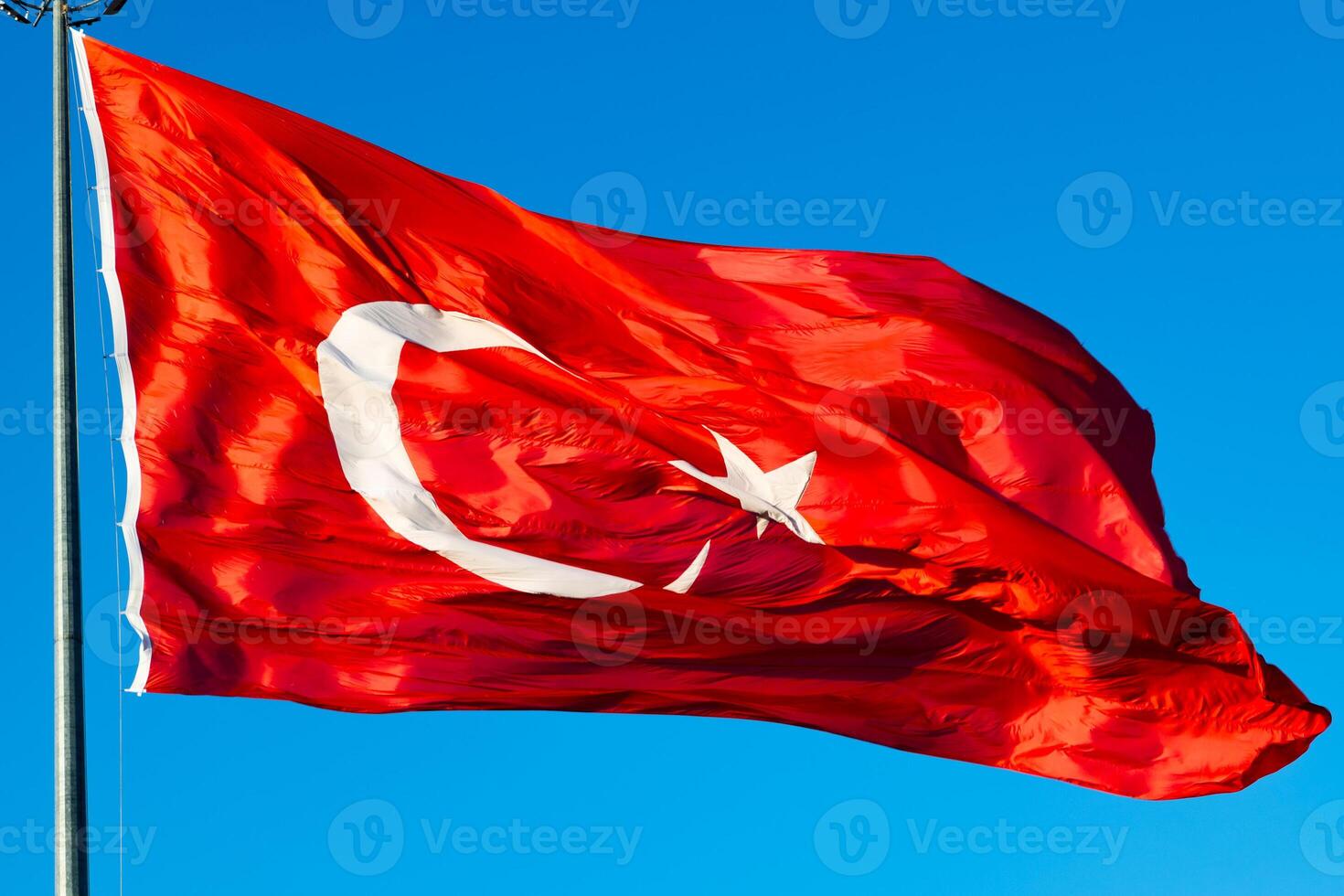 Waving Turkish Flag and flagpole isolated on blue sky background. National holidays of Turkiye concept photo. photo