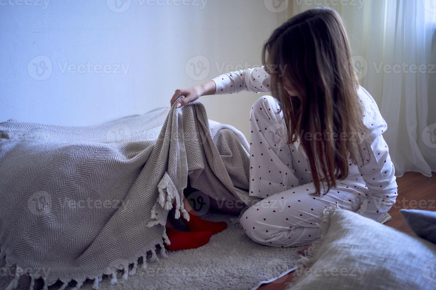 un Adolescente niña construye un fortaleza fuera de almohadas para su pequeño hermano foto