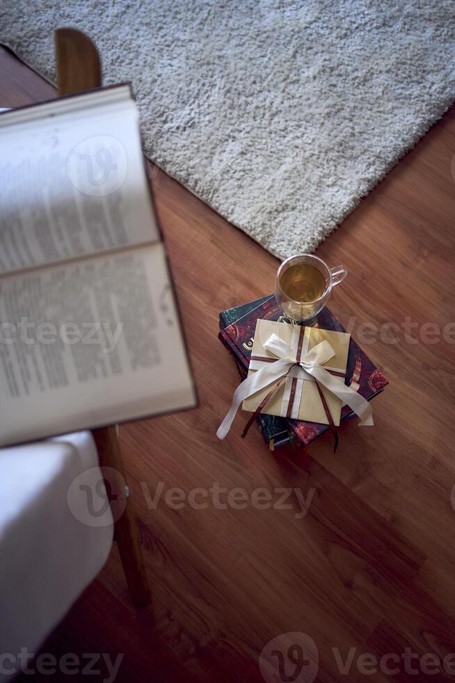 Gift certificate next to  perfect  place for reading and relaxing, a white armchair surrounded by books in a bright room photo