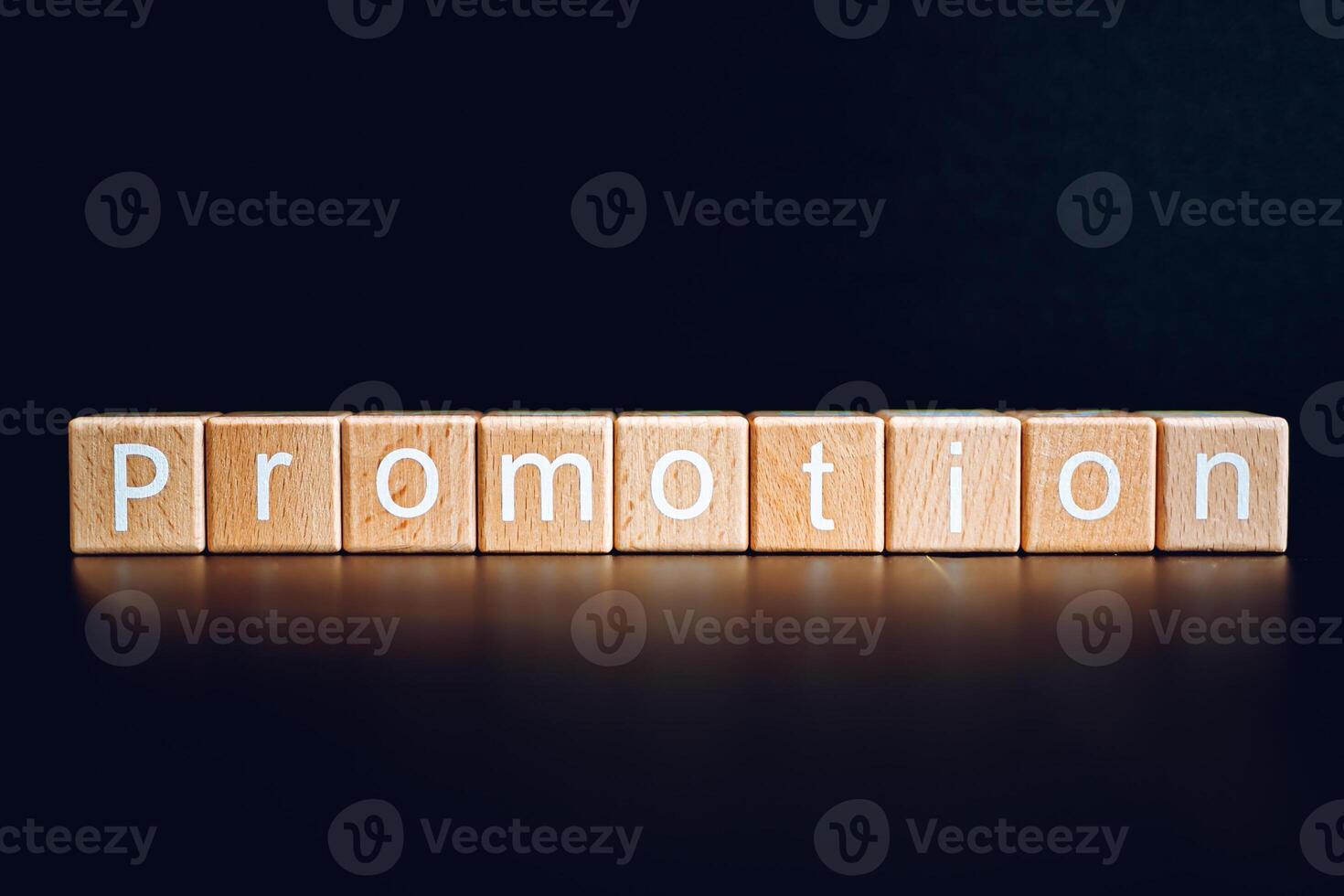 Wooden blocks form the text Promotion against a black background. photo