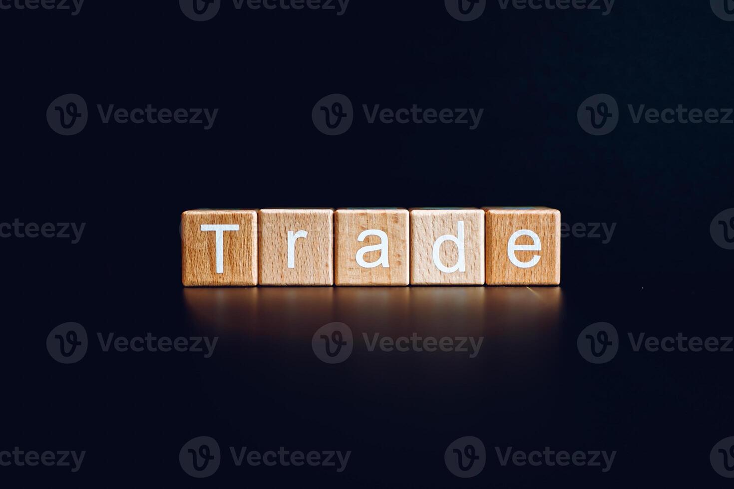 Wooden blocks form the text Trade against a black background. photo