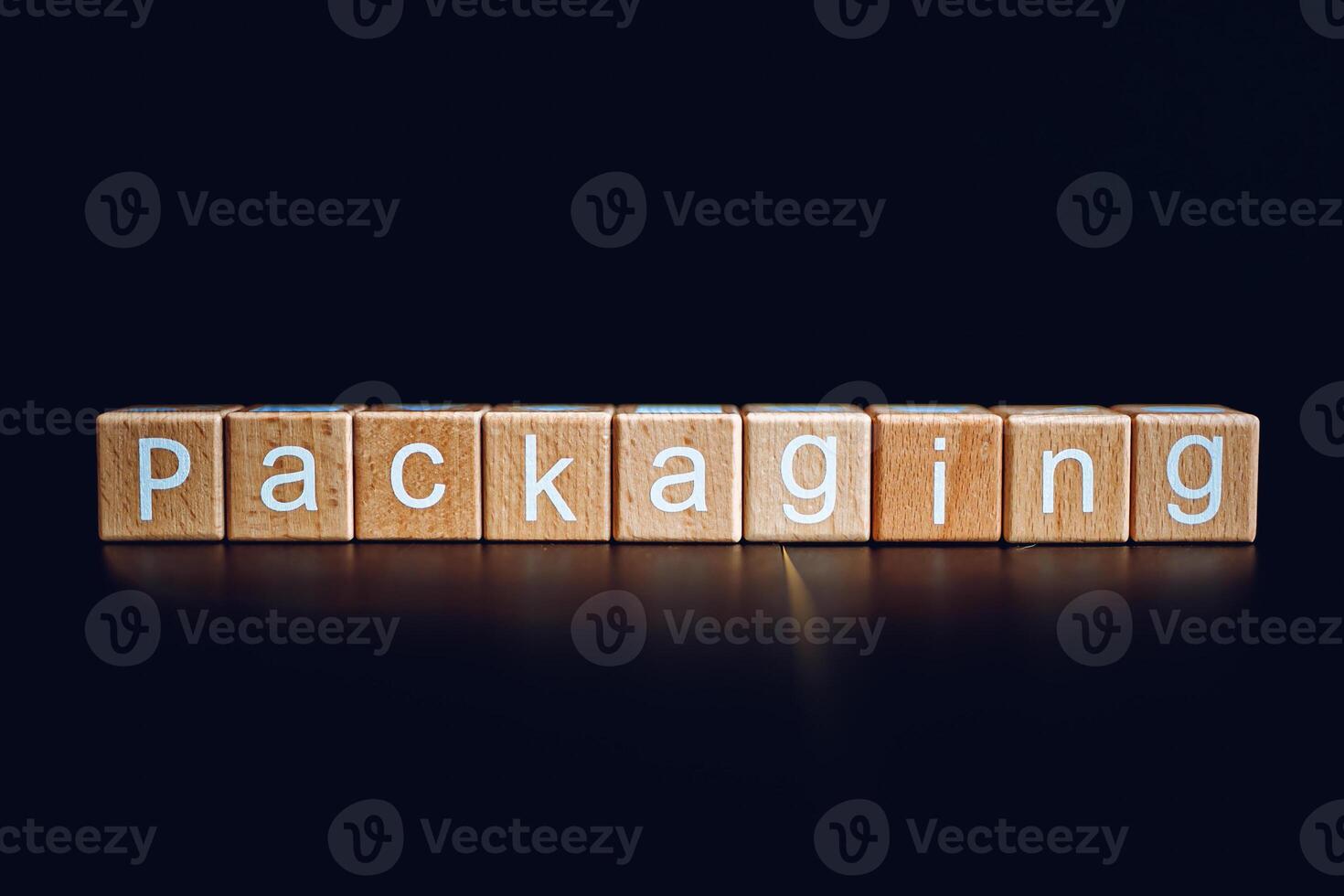 Wooden blocks form the text Packaging against a black background. photo