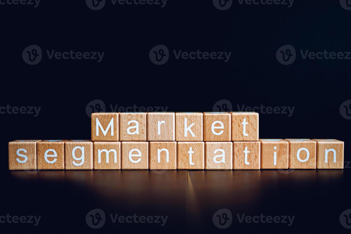 Wooden blocks form the text Market segmentation against a black background. photo