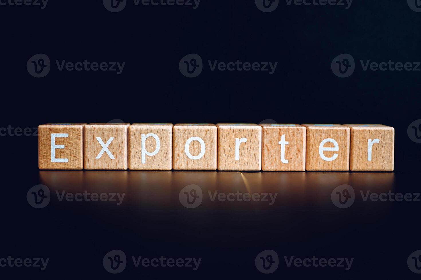 Wooden blocks form the text Exporter against a black background. photo