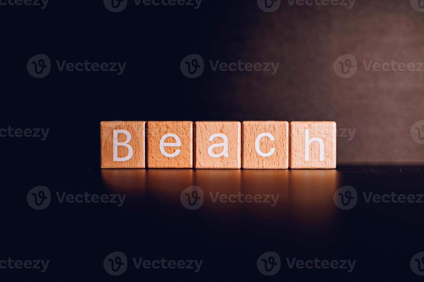 Wooden blocks form the text Beach against a black background. photo