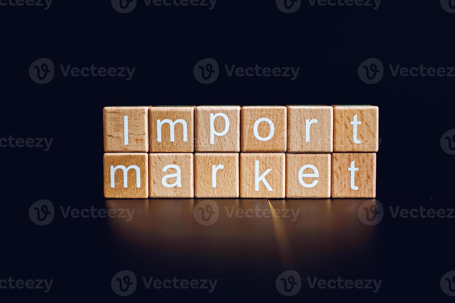 Wooden blocks form the text Import market against a black background. photo