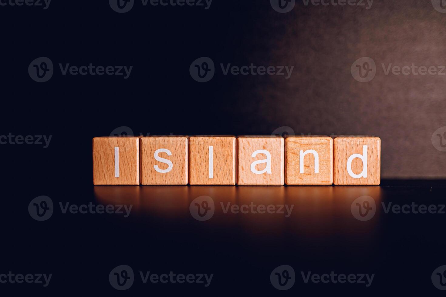 Wooden blocks form the text Island against a black background. photo