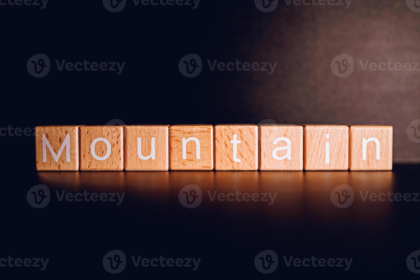 Wooden blocks form the text Mountain against a black background. photo
