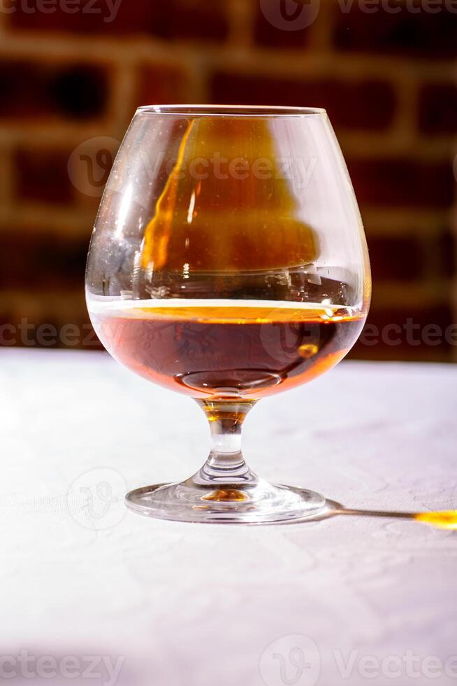 The glare from the glass of French brandy reflected on white tab photo