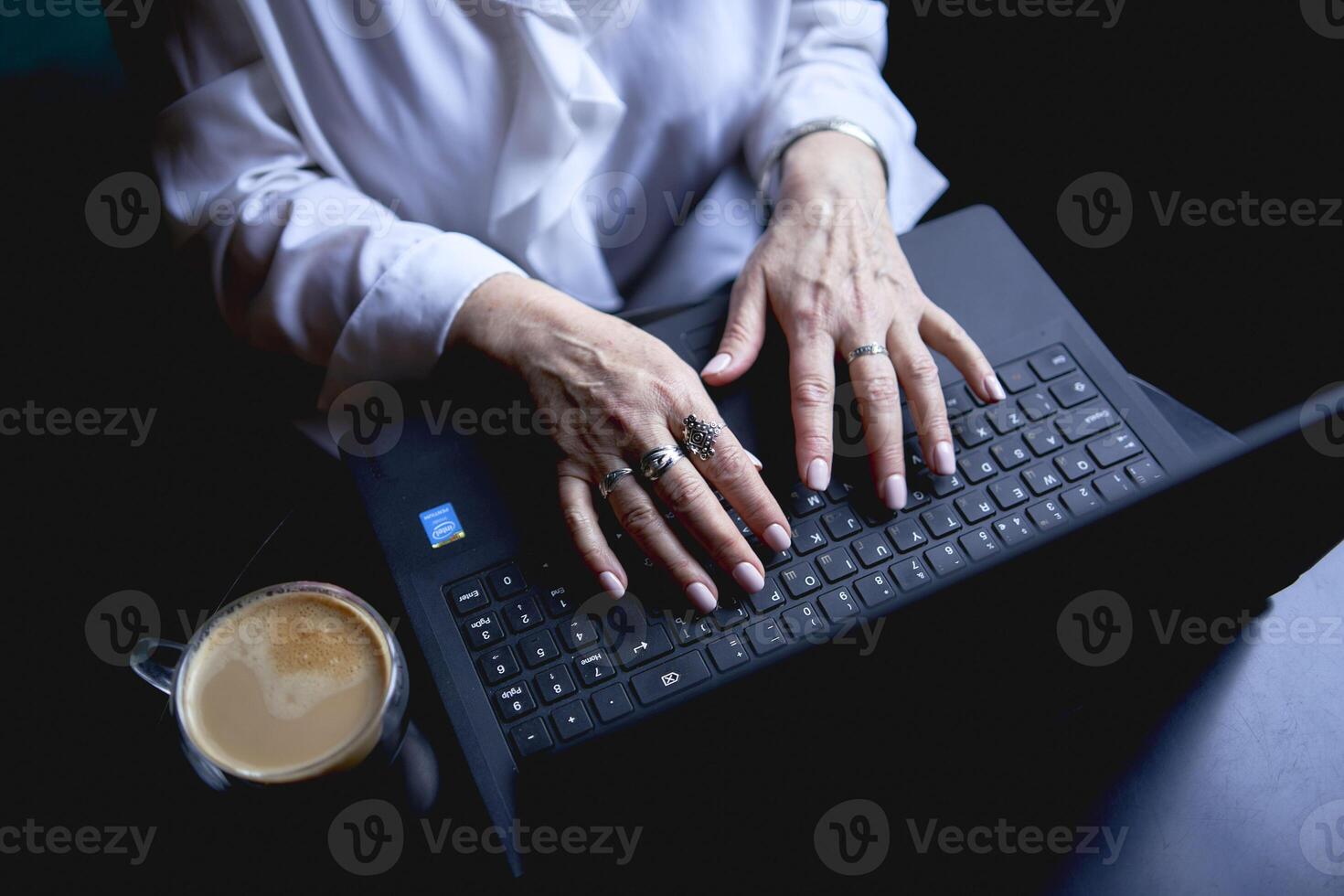 an elderly woman works in a cafe at a laptop photo