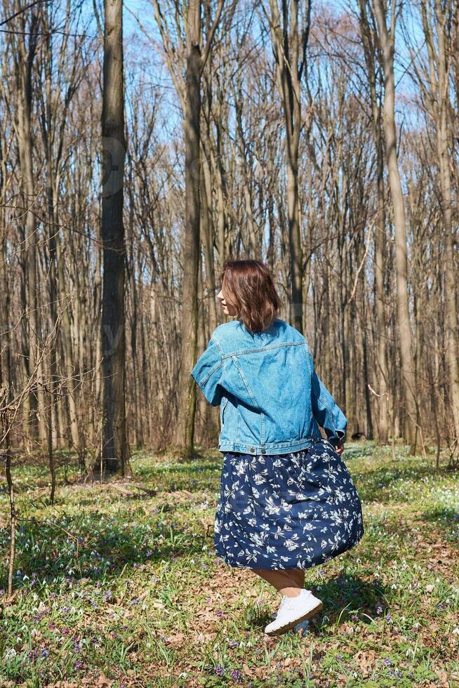 Woman playing with dog in the forest, spring time photo