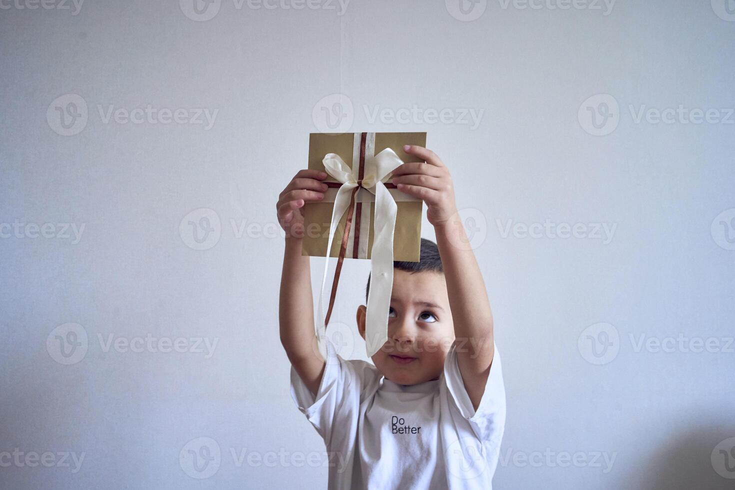 pequeño chico sostiene un arte regalo certificado en su manos foto