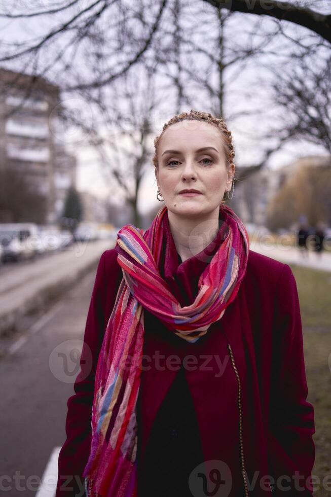 portrait of a stylish middle-aged woman with braids on a spring street photo