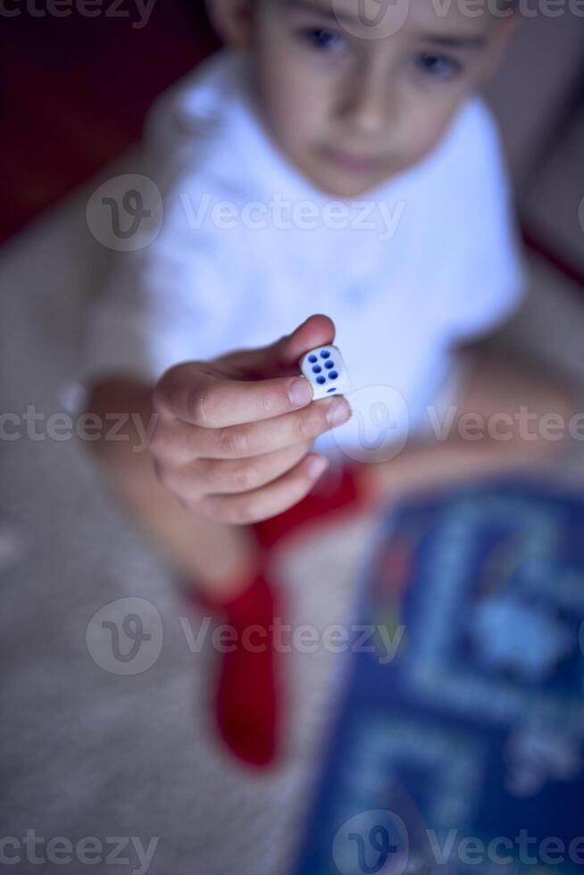 mother with teenage daughter and little son in pajamas playing board games on the floor photo