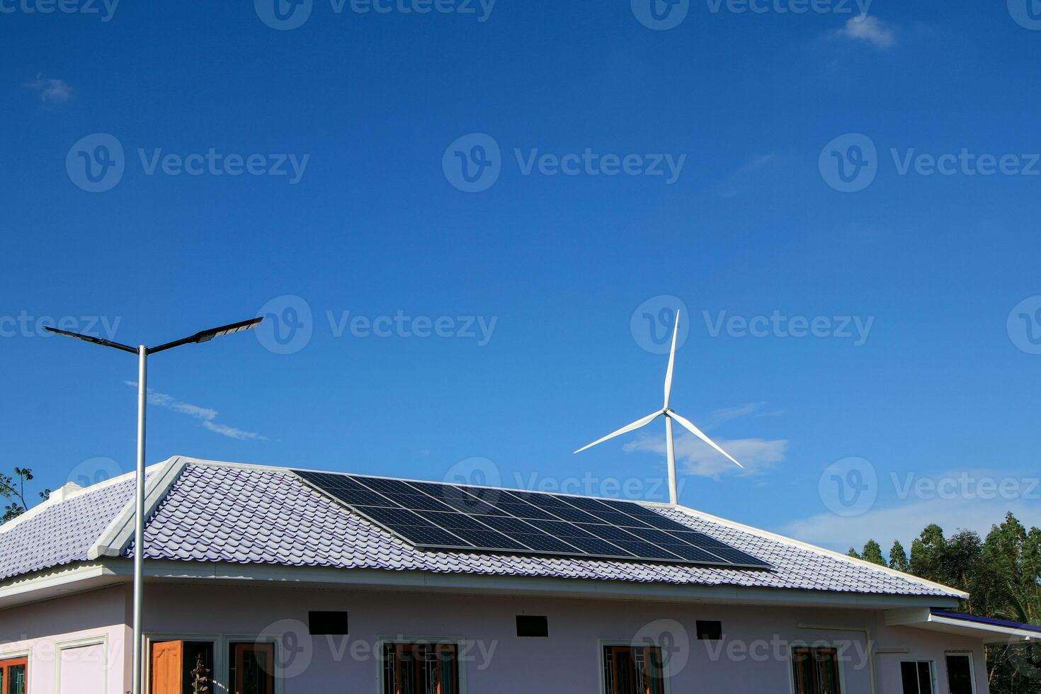 Newly installed solar panels on roofs of houses without access to electricity. Available both indoors and illuminated walkways. There are also wind turbines surrounding the area as well. photo
