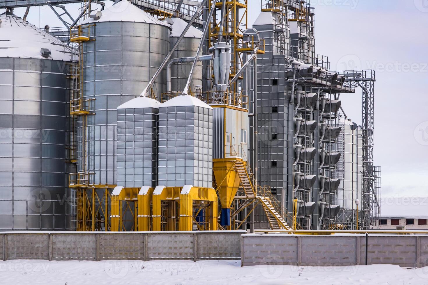 agro-industrial complex with silos and a seed cleaning and drying line for grain storage  in snow of winter field photo