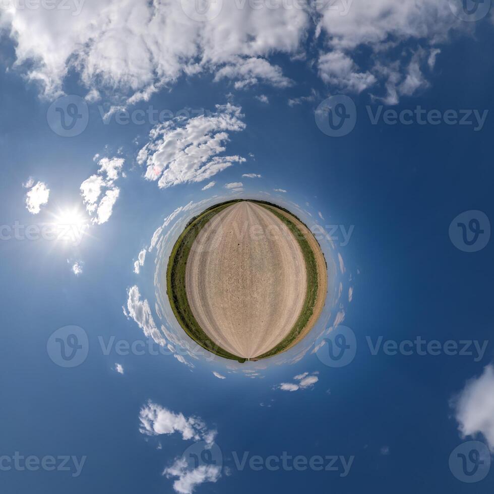 simple green tiny planet without buildings in blue sky with beautiful clouds. Transformation of spherical panorama 360 degrees. Spherical abstract aerial view. Curvature of space. photo