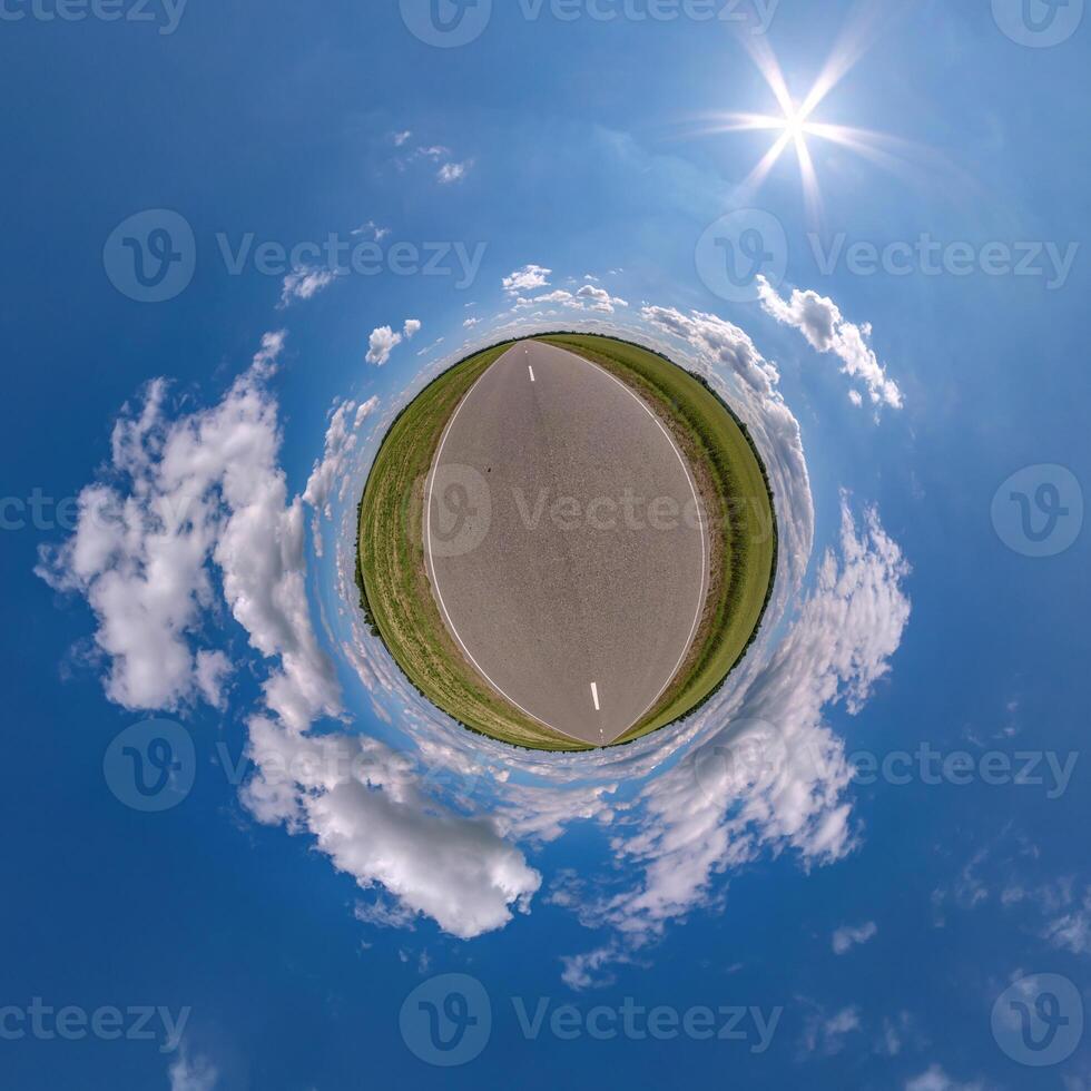 simple green tiny planet without buildings in blue sky with beautiful clouds. Transformation of spherical panorama 360 degrees. Spherical abstract aerial view. Curvature of space. photo